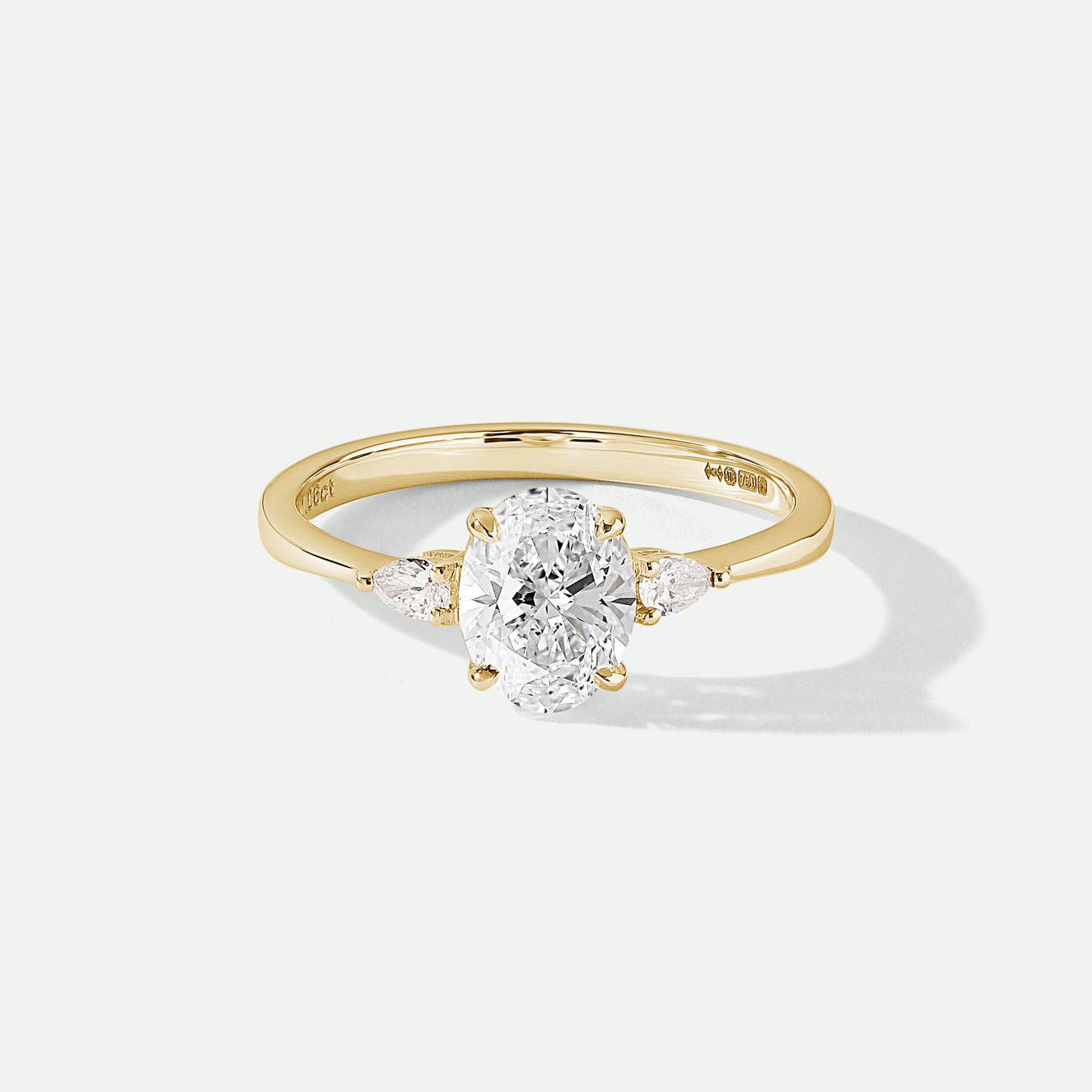 Oval cut lab grown diamond engagement ring with pear shaped sidestones